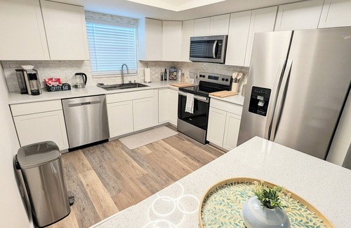 San Carlos Park House | Bright coastal Fort Myers retreat with private fenced yard, inflatable hot tub, fire pit, and outdoor games. Renovated interior, smart TVs in every room, kid-friendly bunk room, and easy parking—perfect for families and relaxed beach getaways.