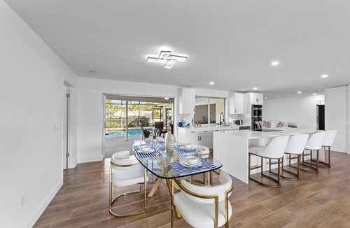 Town and River House | Modern riverfront home 4 br & 3 bath with stunning canal water views, private heated pool, garage & private dock access great for fishing, 4 bikes to explore, and minutes to Sanibel, Captiva, and local beaches.