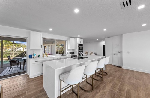 Town and River House | Modern riverfront home 4 br & 3 bath with stunning canal water views, private heated pool, garage & private dock access great for fishing, 4 bikes to explore, and minutes to Sanibel, Captiva, and local beaches.