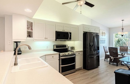 Naples Condo | Relax on the oversized lanai featuring an outdoor kitchen and mid-water view.